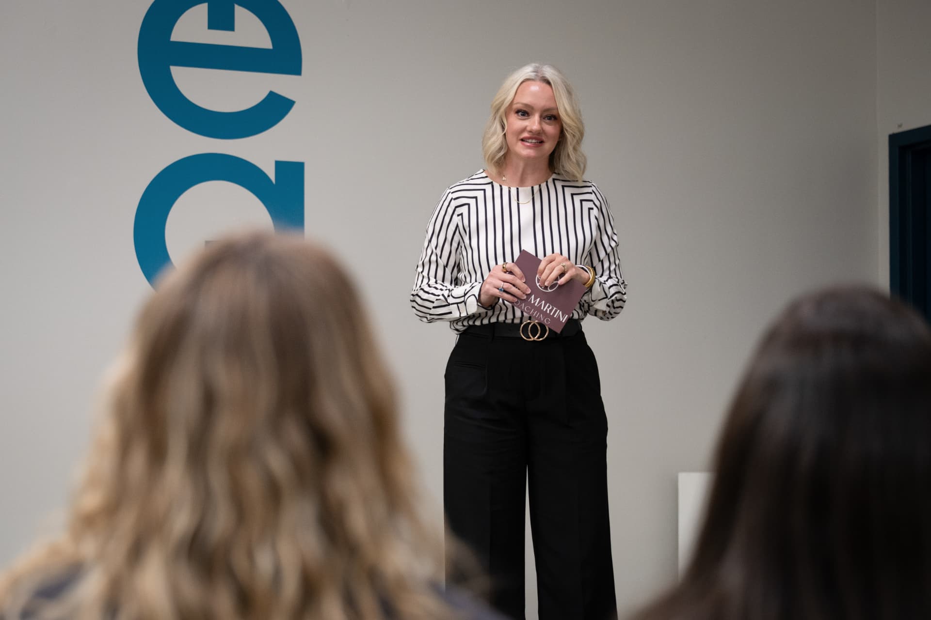 April Martini speaking on stage to an audience